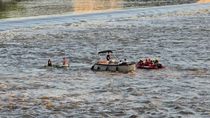 Záchranná akce u Karlova mostu: Člun měl u jezu zmizet pod hladinou, zasahují hasiči