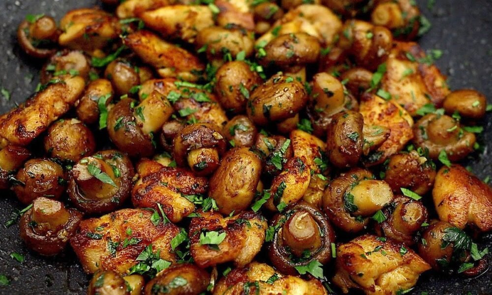 Gebratene Champignons mit Hühnchen in einer Pfanne. Schnell und lecker!
