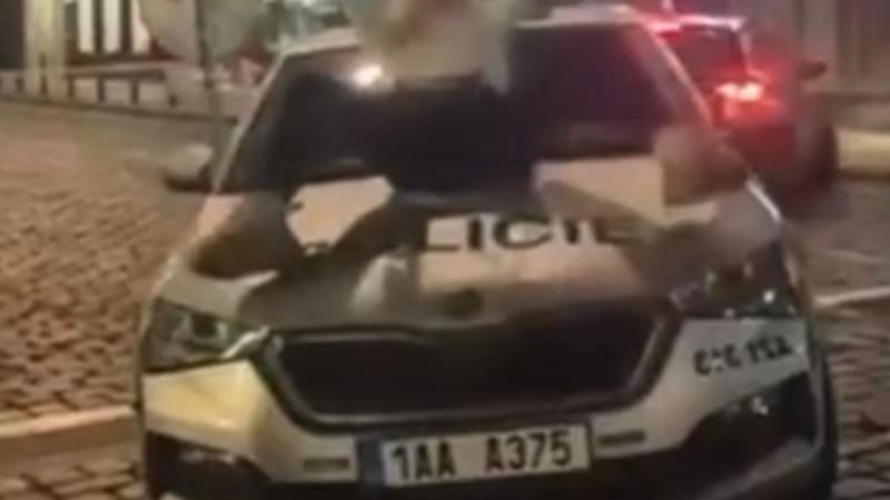 Žena v Praze dováděla na kapotě policejního vozu. „Striptérské kreace“ ji přijdou draho